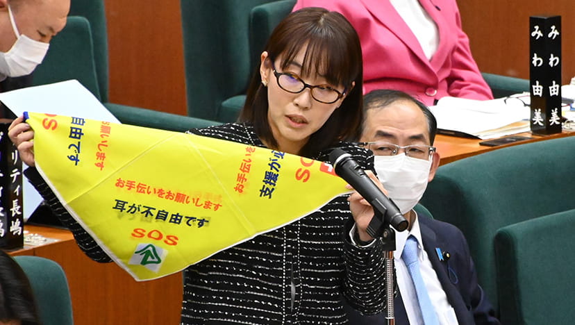 災害時要配慮者用ハンカチを掲げ説明する水野ゆうき